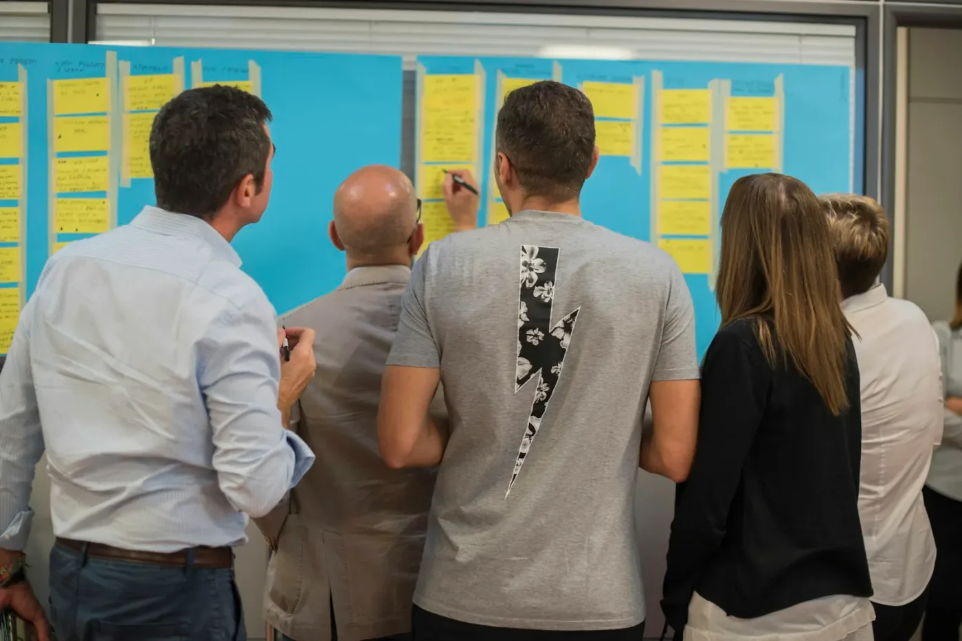Personas revisando un mapa de procesos con notas adhesivas